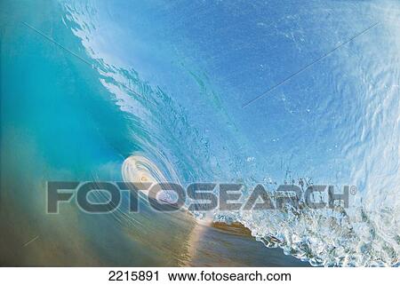 Stock Image - Hawaii, Maui, Makena, Beautiful blue wave breaking at the beach.. Fotosearch