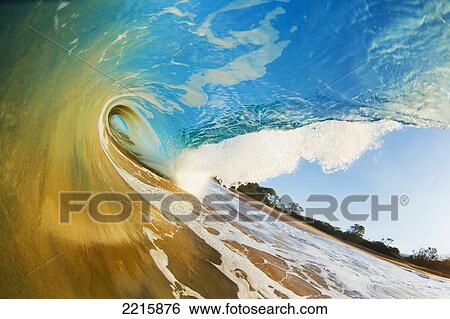 Stock Photograph - Hawaii, Maui, Makena, Beautiful blue ocean wave breaking at the beach.. Fotosearch