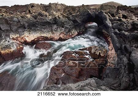 Stock Image - Hawaii, Maui, Makena, Ocean water moving through a lava tube.. Fotosearch