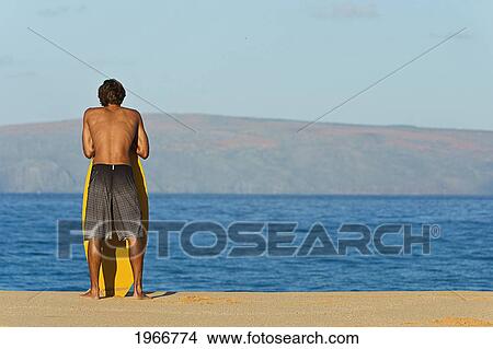 Picture - Hawaii, Maui, Makena, Skimboarder At On The Beach Looking Out At Ocean. Fotosearch