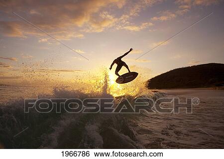 Hawaii, Maui, Makena, Skimboarder Gets Big Air Off A Wave At Sunset View Large Photo Image Stock Photograph - Hawaii, Maui, Makena, Skimboarder Gets Big Air Off A Wave At Sunset. Fotosearch