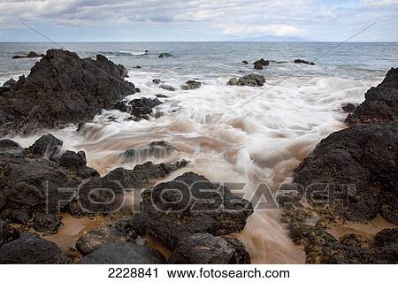 Stock Image - Hawaii, Maui, Makena, Soft Water Crashes On Lava Rocks On The Beach. Fotosearch