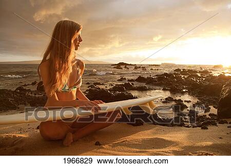 Stock Photo - Hawaii, Maui, Makena, Surfer Girl Sitting On Sand At Sunset. Fotosearch