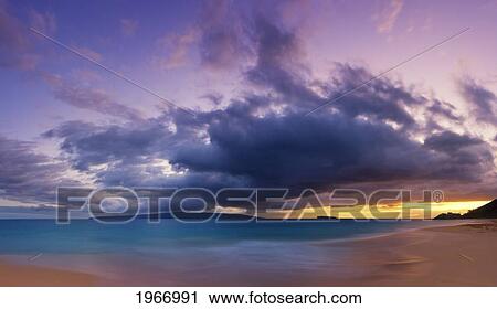 Stock Image - Hawaii, Maui, Makena, Wave Washes Over Sand At Makena Beach At Sunset.. Fotosearch