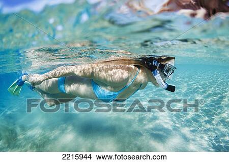 Picture - Hawaii, Maui, Makena, Young woman snorkles in shallow waters.. Fotosearch