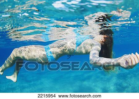 Hawaii, Maui, Makena, Young woman floating near ocean surface, View from below. View Large Photo Image Picture - Hawaii, Maui, Makena, Young woman floating near ocean surface, View from below.. Fotosearch