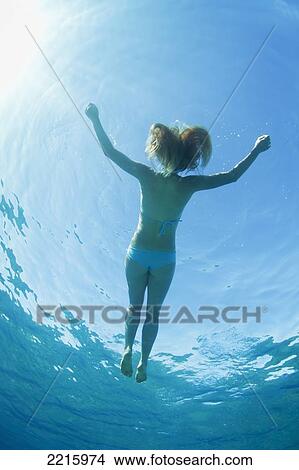 Picture - Hawaii, Maui, Makena, Young woman enjoys floating in the ocean.. Fotosearch