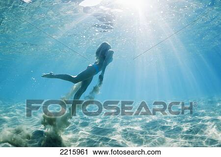 Hawaii, Maui, Makena, Young woman swimming to ocean surface, Creating sand cloud behind her View Large Photo Image Stock Image - Hawaii, Maui, Makena, Young woman swimming to ocean surface, Creating sand cloud behind her. Fotosearch
