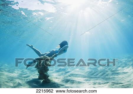 Hawaii, Maui, Makena, Young woman swimming to ocean surface, Creating sand cloud behind her View Large Photo Image Stock Image - Hawaii, Maui, Makena, Young woman swimming to ocean surface, Creating sand cloud behind her. Fotosearch