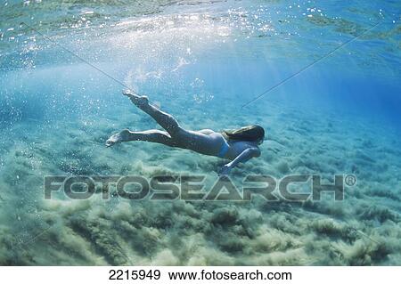 Stock Photo - Hawaii, Maui, Makena, Young woman swimming in ocean.. Fotosearch