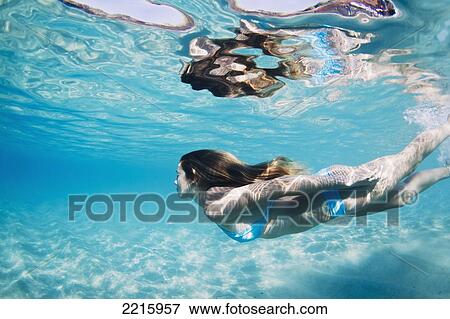 Hawaii, Maui, Makena, Young woman swimming near ocean surface. View Large Photo Image Stock Photo - Hawaii, Maui, Makena, Young woman swimming near ocean surface.. Fotosearch