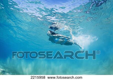 Hawaii, Maui, Makena, Young woman swimming near ocean surface, View from below. View Large Photo Image Stock Photo - Hawaii, Maui, Makena, Young woman swimming near ocean surface, View from below.. Fotosearch