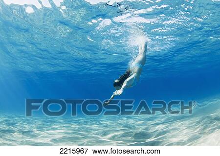 Stock Photo - Hawaii, Maui, Makena, Young woman diving to ocean floor.. Fotosearch