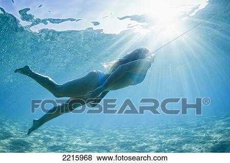 Stock Photo - Hawaii, Maui, Makena, Young woman enjoys a swim in the ocean.. Fotosearch
