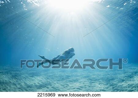 Stock Photo - Hawaii, Maui, Makena, Young woman enjoys a swim in the ocean.. Fotosearch