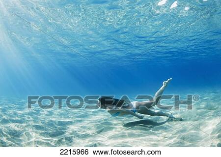Stock Photograph - Hawaii, Maui, Makena, Young woman swimming along the ocean floor.. Fotosearch