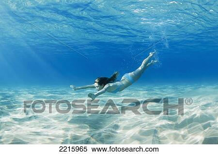 Stock Photography - Hawaii, Maui, Makena, Young woman swimming along the ocean floor.. Fotosearch