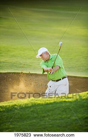 Stock Image - Hawaii, Maui, Male Golfer Swinging Golf Club At The Maui Country Club Course.. Fotosearch