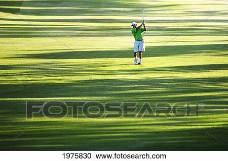 Stock Image - Hawaii, Maui, Male Golfer Swinging Golf Club At The Maui Country Club Course.. Fotosearch
