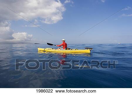 Stock Image - Hawaii, Maui, Man In Yellow Kayak Along The Calm Ocean Of The Southern Coast.. Fotosearch
