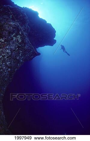 Stock Photo - Hawaii, Maui, Molokini, Diver In Distance Alongside Black Wall, Silhouette A81G. Fotosearch