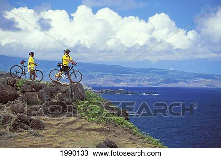 Hawaii, Maui, Mountain Bikers Enjoying View Along Coast, Standing On Cliff View Large Photo Image Stock Image - Hawaii, Maui, Mountain Bikers Enjoying View Along Coast, Standing On Cliff. Fotosearch