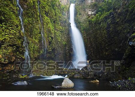 Hawaii, Maui, Nahiku, Woman Standing At Base Of Hanawi Falls. View Large Photo Image Stock Photo - Hawaii, Maui, Nahiku, Woman Standing At Base Of Hanawi Falls.. Fotosearch
