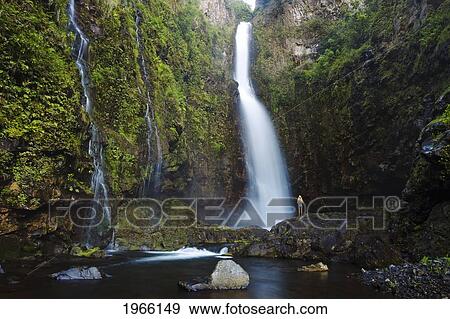 Hawaii, Maui, Nahiku, Woman Standing At Base Of Hanawi Falls. View Large Photo Image Stock Photo - Hawaii, Maui, Nahiku, Woman Standing At Base Of Hanawi Falls.. Fotosearch