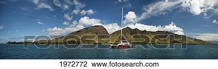 Stock Image - Hawaii, Maui, Olowalu And The West Maui Mountains, A Sailing Catamaran Floats On The Ocean.. Fotosearch