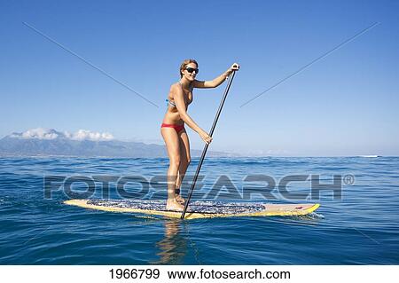 Stock Photo - Hawaii, Maui, Paia, Young Woman Stand Up Paddling Shore/Nno Commercial Use. Fotosearch