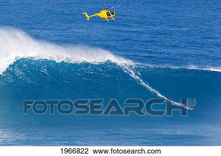Stock Image - Hawaii, Maui, Peahi (Jaws), Helicopter, Surfer Rides A Giant Wave. Fotosearch