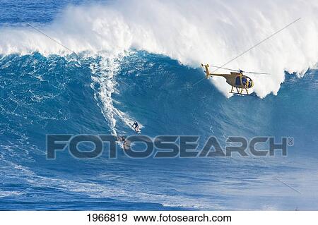 Stock Photo - Hawaii, Maui, Peahi (Jaws), Helicopter, Two Surfer Ride A Giant Wave. Fotosearch
