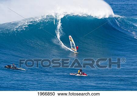 Stock Image - Hawaii, Maui, Peahi (Jaws), Windsurfer Rides Large Wave And Two Jetskiers In Foreground. Fotosearch