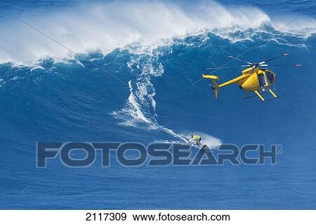 Stock Photo - Hawaii, Maui, Professional windsurfer Robby Naish catches a large wave at Peahi, also know as Jaws. EDITORIAL USE ONLY.. Fotosearch