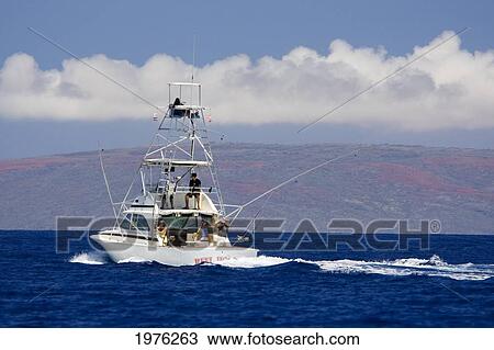 Stock Image - Hawaii, Maui, Sportfishing Boat Cruises In Blue Ocean Water, Kahoolawe In Background.. Fotosearch