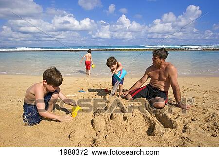 Hawaii, Maui, Spreckelsville, Baby Beach, Family On Vacation Building A Sandcastle. View Large Photo Image Stock Image - Hawaii, Maui, Spreckelsville, Baby Beach, Family On Vacation Building A Sandcastle.. Fotosearch
