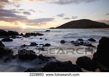 Stock Image - Hawaii, Maui, Sunset From The Rocky Shore Of Makena Beach.. Fotosearch