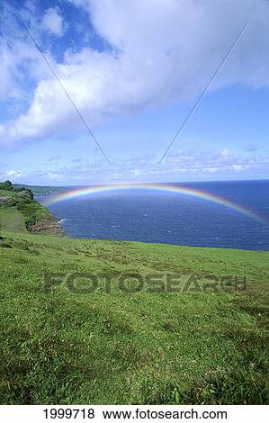 Stock Photo - Hawaii, Maui, View Of Rainbow Over Deep Blue Ocean, Pale Blue Sky, White Clouds C1733. Fotosearch
