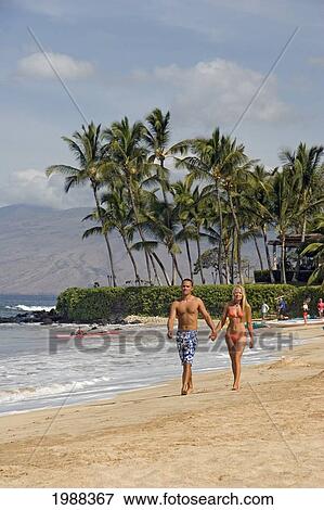 Stock Photo - Hawaii, Maui, Wailea Beach, Couple On Vacation Walking Down The Beach Holding Hands. Fotosearch