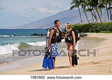 Stock Image - Hawaii, Maui, Wailea Beach, Couple Wearing Scuba Gear Standing On The Beach. Fotosearch