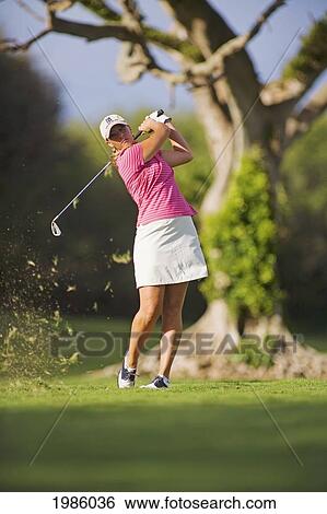 Hawaii, Maui, Wailea Gold Golf Course, Female Golfer Swinging Golf Club, Turf Flying From Club, View From Front. View Large Photo Image Stock Photograph - Hawaii, Maui, Wailea Gold Golf Course, Female Golfer Swinging Golf Club, Turf Flying From Club, View From Front.. Fotosearch