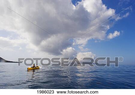 Stock Image - Hawaii, Maui, Woman In Yellow Kayak Along The Calm Ocean Of The Southern Coast.. Fotosearch