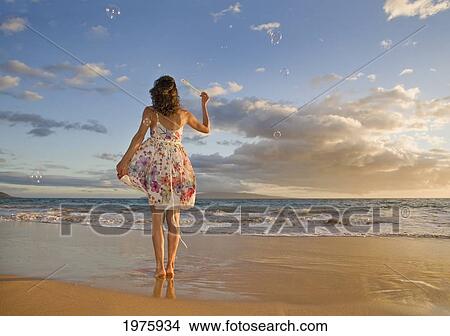 Hawaii, Maui, Woman Standing On The Shore Of Remote Tropical Location Blowing Bubbles. View Large Photo Image Picture - Hawaii, Maui, Woman Standing On The Shore Of Remote Tropical Location Blowing Bubbles.. Fotosearch