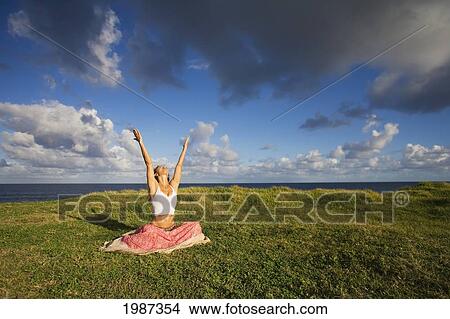 Picture - Hawaii, Maui, Young Woman Doing Yoga On Grassy Hill Next To The Ocean.. Fotosearch