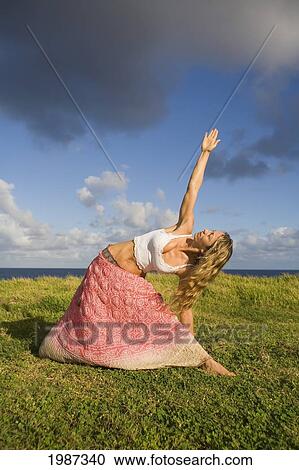 Hawaii, Maui, Young Woman Doing Yoga On Grassy Hill Next To The Ocean. View Large Photo Image Stock Image - Hawaii, Maui, Young Woman Doing Yoga On Grassy Hill Next To The Ocean.. Fotosearch
