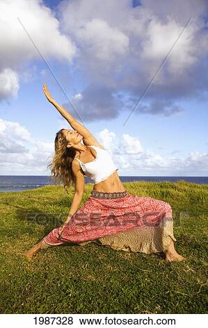 Hawaii, Maui, Young Woman Doing Yoga On Grassy Hill Next To The Ocean. View Large Photo Image Stock Photo - Hawaii, Maui, Young Woman Doing Yoga On Grassy Hill Next To The Ocean.. Fotosearch