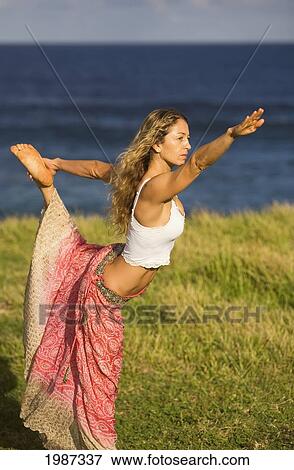 Stock Photo - Hawaii, Maui, Young Woman Doing Yoga On Grassy Hill Next To The Ocean.. Fotosearch