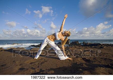 Stock Image - Hawaii, Maui, Young Woman Doing Yoga Next To The Ocean.. Fotosearch
