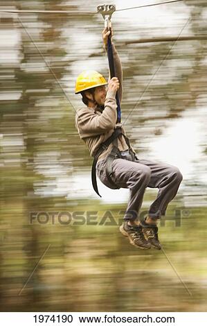 Stock Image - Hawaii, Maui, Zipline Adventure, Man Riding The Zipline.. Fotosearch