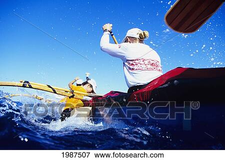 Stock Photo - Hawaii, Molokai To Oahu, Kaiwi Channel, Na Wahine O Kekai Race, View From Ocean Of Women's Paddling Team During Change. No Model Release. Fotosearch